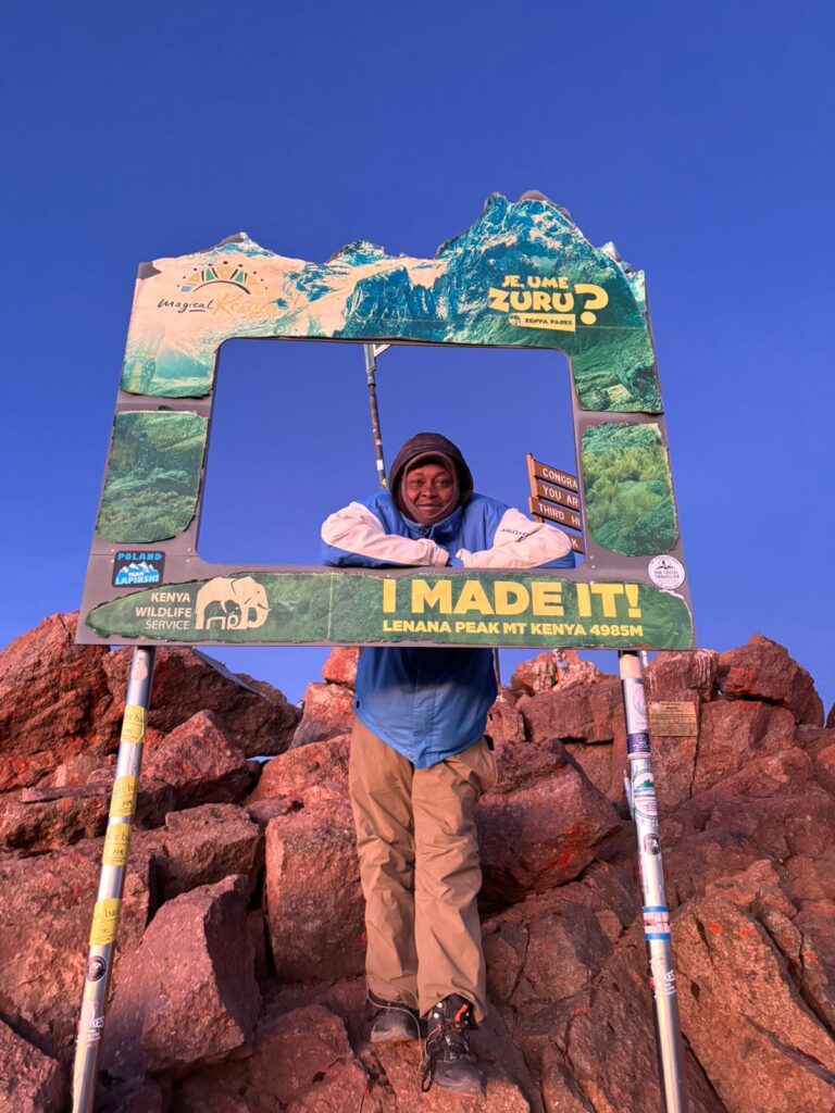 Trekker at the I Made It frame on Point Lenana, Mount Kenya 4,985m