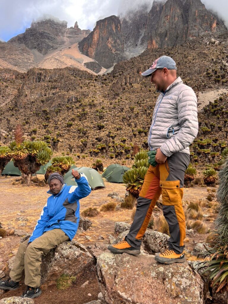 Mount Kenya crew at camp among giant groundsels, tents pitched below the peaks
